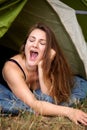 Young brunette woman lying in tent and yawning Royalty Free Stock Photo