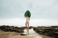 Portrait young brunette woman with a palm leaf standing on background coast sea Royalty Free Stock Photo