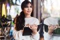 Portrait of young brunette woman standing in cafe, writing in notebook, looking out window. Girl makes notes in diary, plans Royalty Free Stock Photo