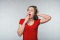 Portrait of young brunette woman student covering mouth with hand during sweet morning yawn Royalty Free Stock Photo