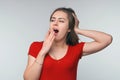 Portrait of young brunette woman student covering mouth with hand during sweet morning yawn Royalty Free Stock Photo