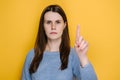 Portrait of young brunette woman warning with admonishing finger gesture, saying no, giving advice to avoid danger