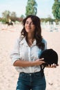 Portrait of young brunette woman in a white shirt with a helmet in a hands