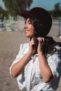 Portrait of young brunette woman in a white shirt whith a helmet in a hands