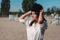 Portrait of young brunette woman in a white shirt whith a helmet in a hands