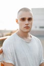 Portrait of a young brutal man in a stylish gray shirt outdoors.