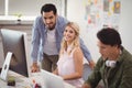 Portrait of young business colleagues working on desktop pc at office desk Royalty Free Stock Photo