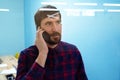 Portrait of a young business man having a conversation on the phone at the workplace, looking out the window. Close-up Royalty Free Stock Photo