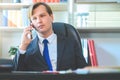 Portrait of young business man sitting at his desk in the office Royalty Free Stock Photo