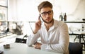 Portrait of a young business man using smart phone and working in cafe. Royalty Free Stock Photo