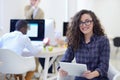 Portrait of young business woman at modern startup office interior, team in meeting in background Royalty Free Stock Photo