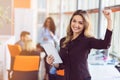 Portrait of young business woman at modern startup office interior, team in meeting in background Royalty Free Stock Photo