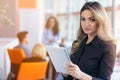 Portrait of young business woman at modern startup office interior, team in meeting in background Royalty Free Stock Photo