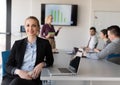 Portrait of young business woman at office with team on meeting Royalty Free Stock Photo