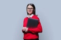 Portrait of young business woman holding laptop, on grey background Royalty Free Stock Photo