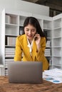 Portrait of young business woman with sitting in office in front of her laptop and talking on mobile phone Royalty Free Stock Photo