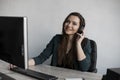 Portrait of young business woman talking phone against computer screen in white office. Female entrepreneur having call Royalty Free Stock Photo