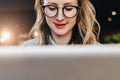 Portrait of young business woman in trendy glasses sitting in cafe,working on laptop.Blogger communicates with followers Royalty Free Stock Photo