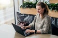 Portrait of young business woman in trendy glasses sitting in cafe,working on laptop.Blogger communicates with followers Royalty Free Stock Photo