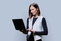 Portrait of young business woman using laptop on gray background Royalty Free Stock Photo