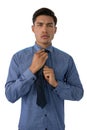 Portrait of young businessman adjusting necktie Royalty Free Stock Photo