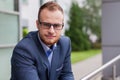 Portrait of young businessman with beard standing in front of of Royalty Free Stock Photo