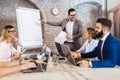 Young businessman giving presentation to his colleagues in office Royalty Free Stock Photo