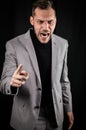 Portrait of a young businessman in a gray suit, very angry yelling and gesturing accusingly in front of him Royalty Free Stock Photo