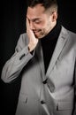 Portrait of a young businessman in a gray suit who is extremely tired rubs his face trying to recover Royalty Free Stock Photo