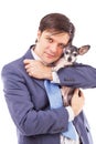 Portrait of a young businessman holding a cute chihuahua dog Royalty Free Stock Photo