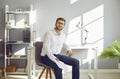 Portrait of young businessman sitting on chair at his workplace Royalty Free Stock Photo