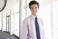 Portrait Of Young Businessman Standing In Corridor Of Modern Off