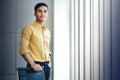 Portrait of Young Businessman Standing by the Window in Office. Looking at Camera and Smiling. Happy Person