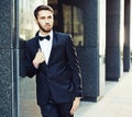 Portrait. Young businessman in a suit and bow tie posing on background of office building. market. course. success Royalty Free Stock Photo