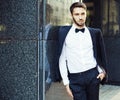 Portrait. Young businessman in a suit and bow tie posing on background of office building. Market. Course. Success Royalty Free Stock Photo