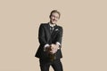 Portrait of a young businessman uncorking champagne over colored background