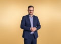 Portrait of young businessman wearing glasses and elegant blue suit clasping his hands. Male professional posing confidently while Royalty Free Stock Photo