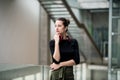 A portrait of young businesswoman with headphones standing in corridor outside office. Royalty Free Stock Photo
