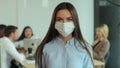 Portrait of young businesswoman in medical mask. Woman business, sales manager worker in large coworking open space