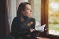 Portrait of young businesswoman with notebook and phone at window Royalty Free Stock Photo