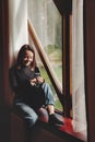 Portrait of young businesswoman with notebook and phone at window Royalty Free Stock Photo