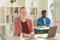 Smiling Young Woman in Sunlit Office Royalty Free Stock Photo