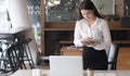 Portrait of young businesswoman standing at her desk using a laptop Royalty Free Stock Photo