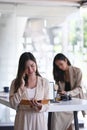 Portrait of young businesswoman is talking on phone and her colleague in the background. Royalty Free Stock Photo