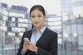 Portrait of young businesswoman texting on her phone, cityscape in background Royalty Free Stock Photo