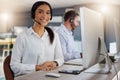 Success is worth all the effort. Portrait of a young call centre agent working on a computer in an office at night. Royalty Free Stock Photo