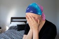 Portrait of a young cancer patient in a headscarf holding head in hands Royalty Free Stock Photo