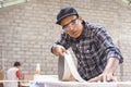 Young carpenter applying wood vinyl into a furniture