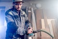 Portrait of a young carpenter working with an electrical plane in a home wood workshop. The concept of a business idea