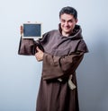 Portrait of Young catholic monk with board